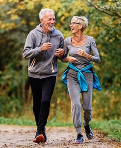 Older couple walking outdoors laughing