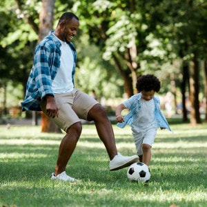man plays soccer with child