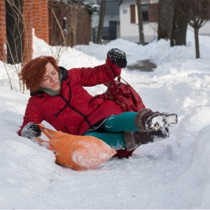 woman falls on slippery snowy sidewalk carrying bags