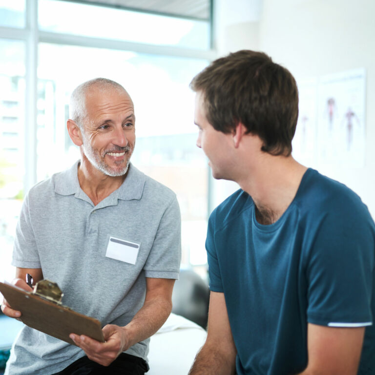 physical therapist talks to a patient during an initial appointment