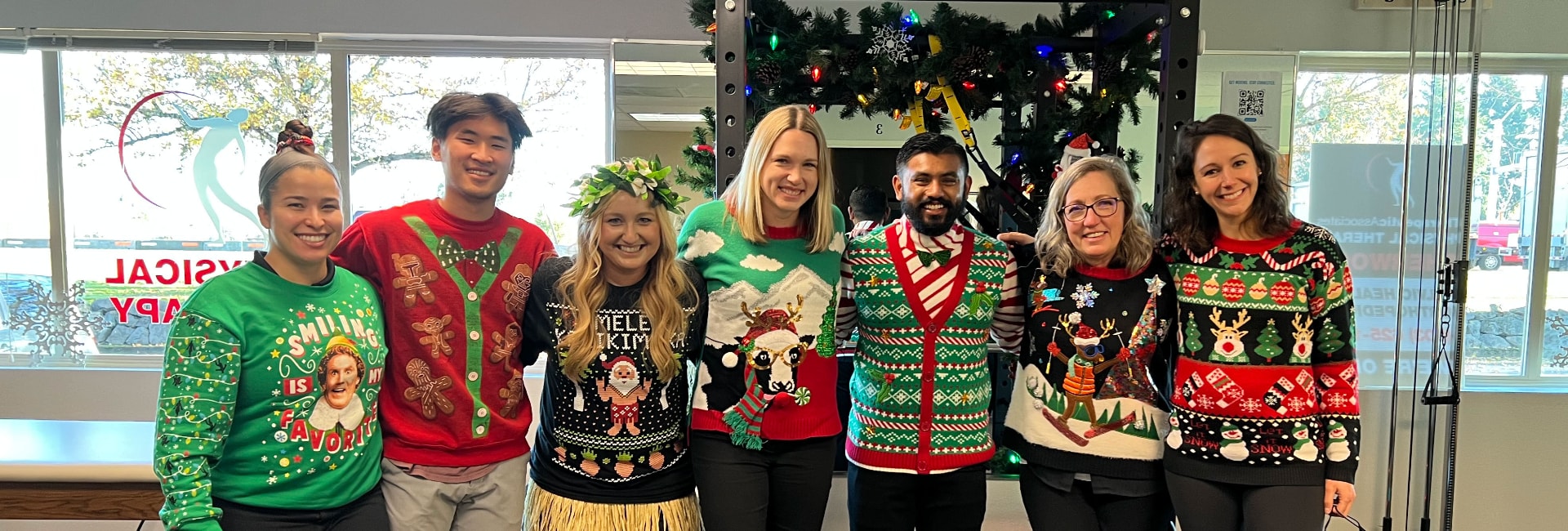 Team of physical therapists celebrate the holidays with festive sweaters.