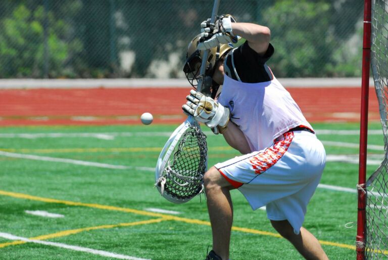 lacrosse goalie prepared to defend the goal from an incoming shot