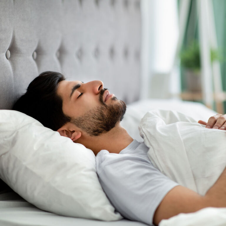 man sleeps soundly in good sleep posture on his back with a good pillow