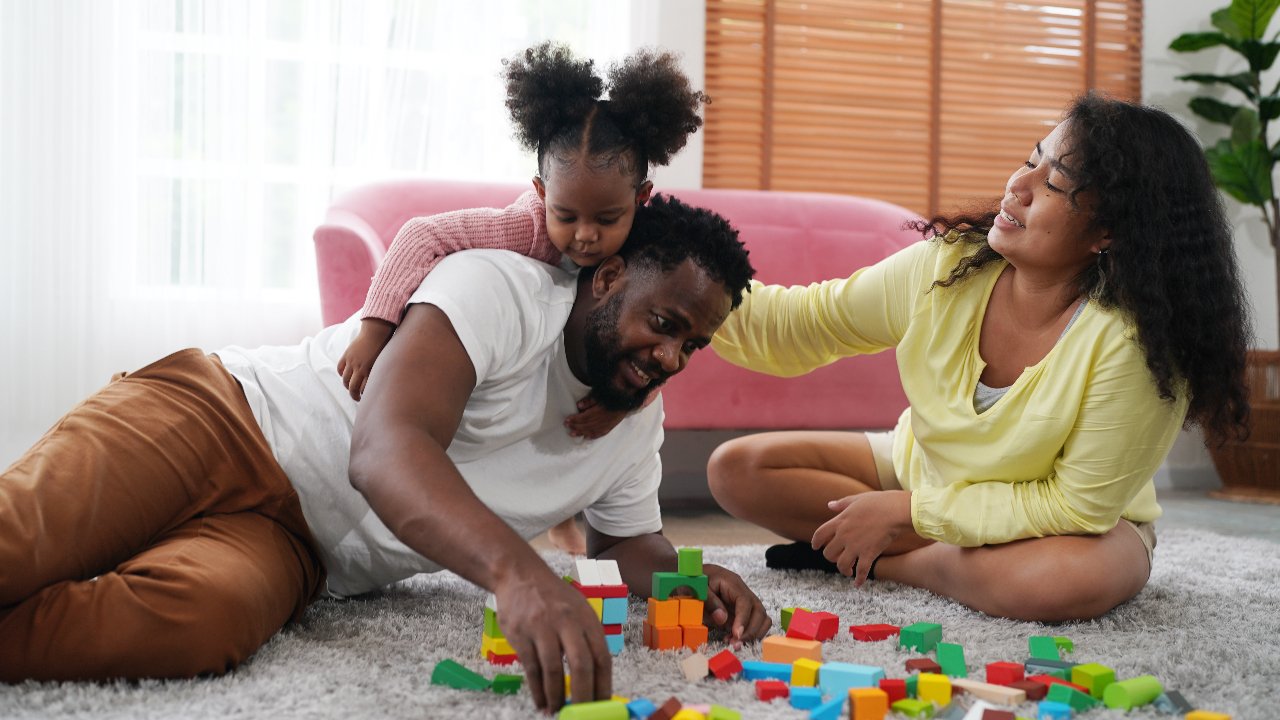 happy African family having playful time on floor with blocks
